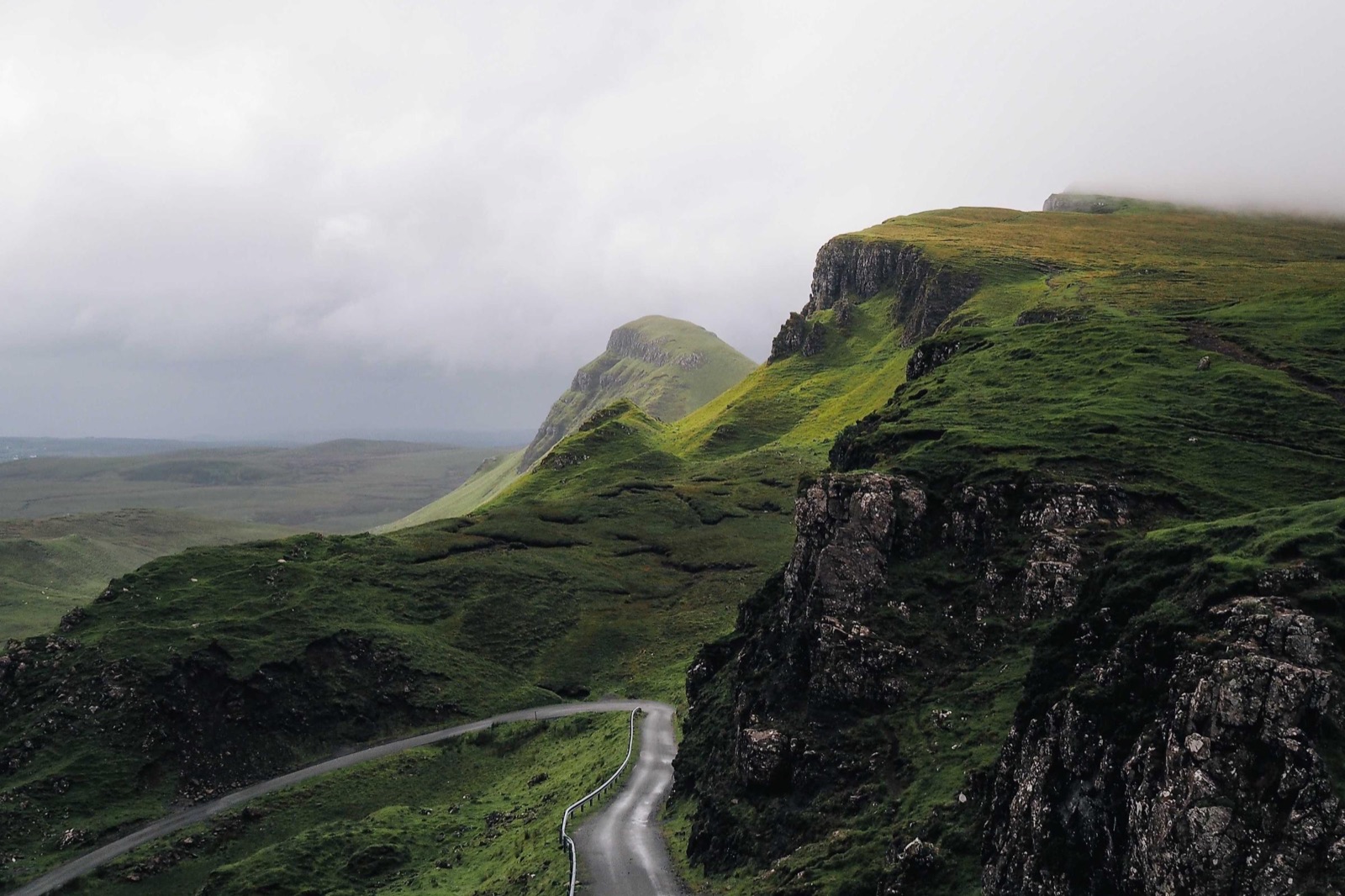 A green coastal hillside under a grey sky, an example of a photo recovered at full resolution.
